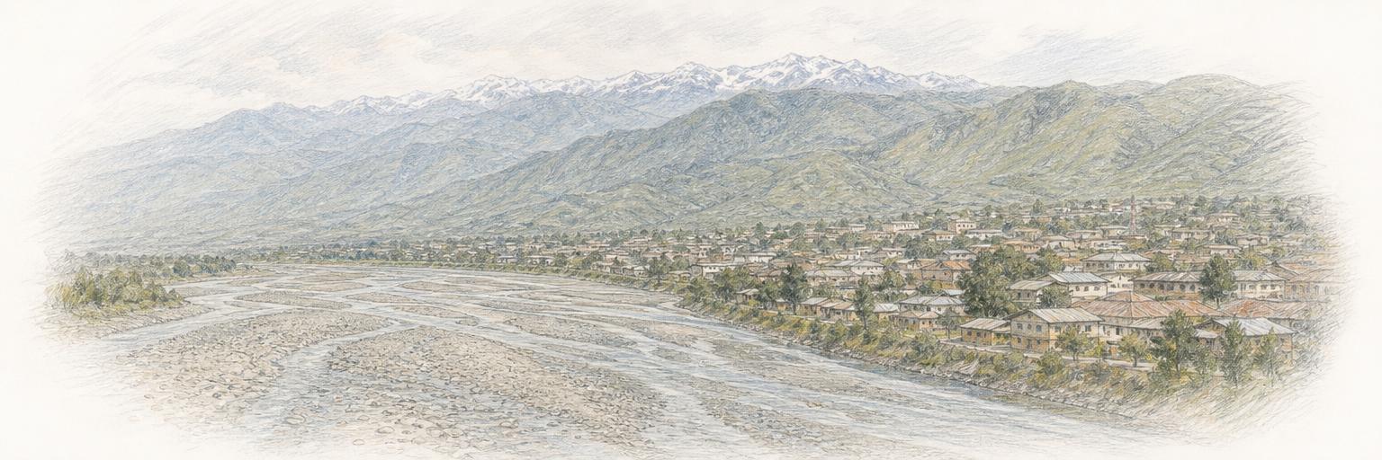 The Nyamwamba riverbed running past the town below the green Rwenzori range near Kasese.
